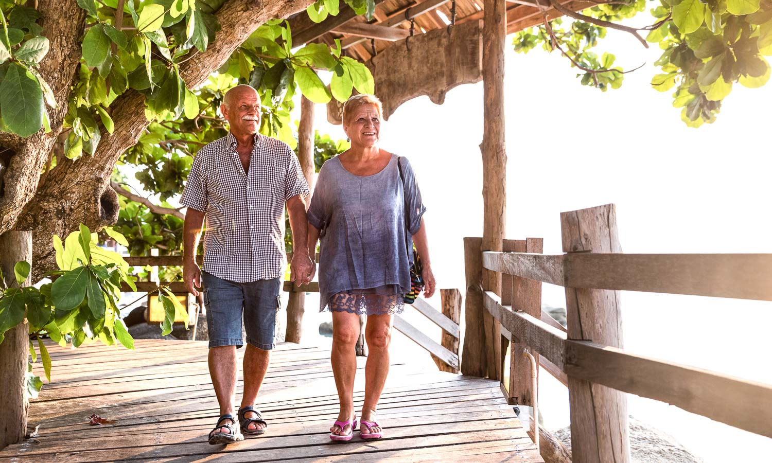 happy senior couple walking holding hand koh phangan beach promenade