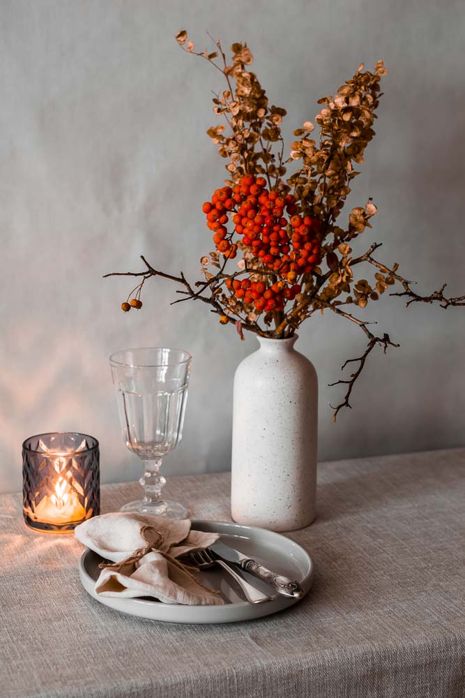 cozy autumn serving plate cutlery napkin vase with rowan branches lit candle table