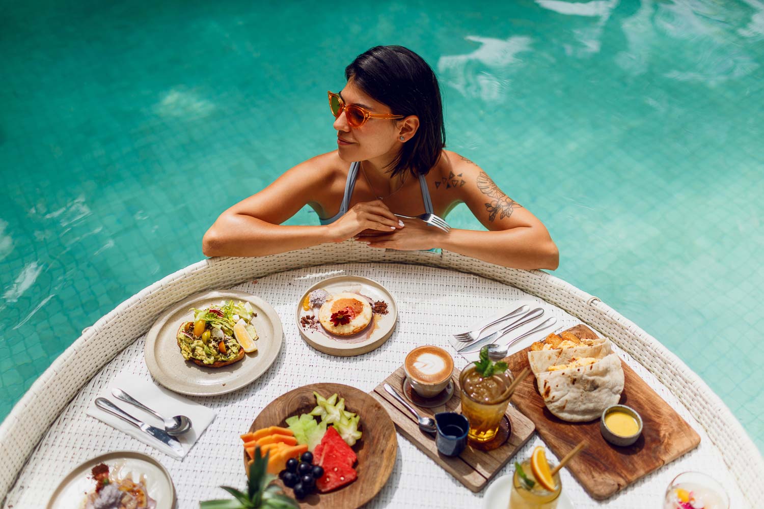 young sexy woman with tattoo bathing suit having breakfast private pool girl relaxing pool drinking coffee eating fruits fruit plate smoothie bowl by hotel pool